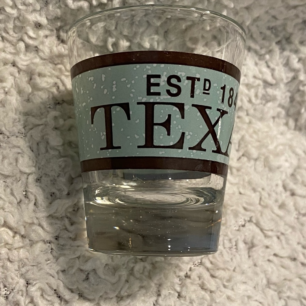 Texas shot glass with wrapped around graphic words Texas est’d 1845